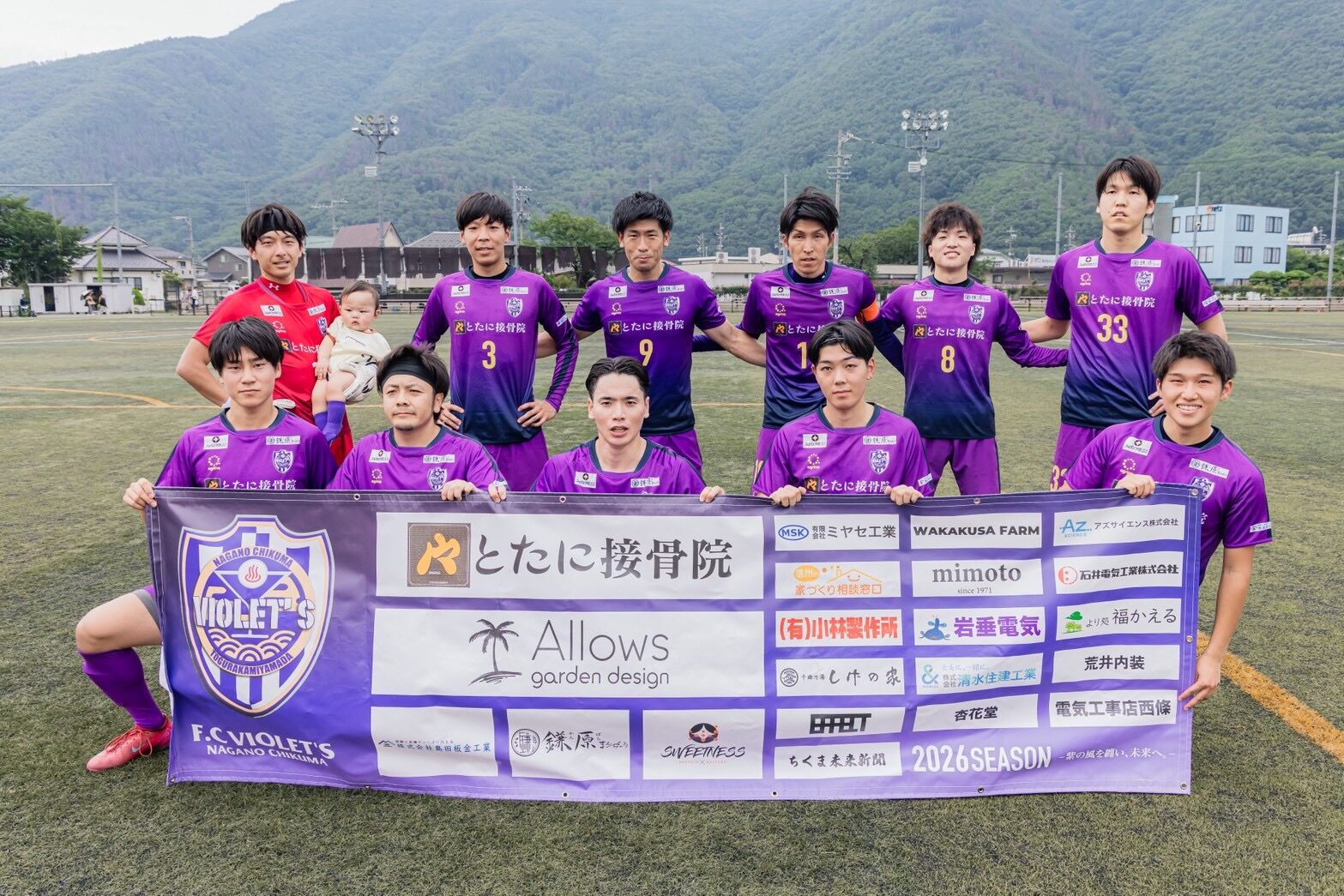 トップチームの選手たちが横断幕を掲げた集合写真